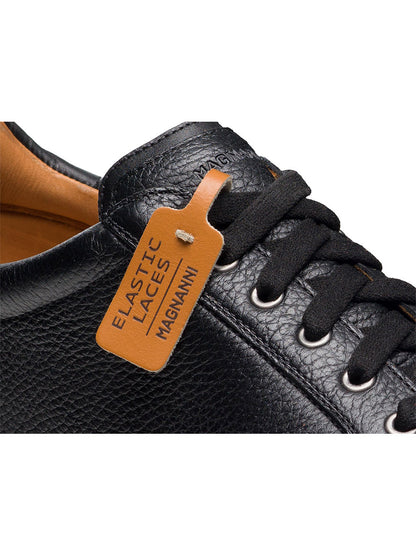Close-up of the Magnanni Cote Lo Stretch-Lace in Tumbled Black, a men’s low-top sneaker with black elastic stretch laces and a brown tag labeled "ELASTIC LACES MAGNANNI.