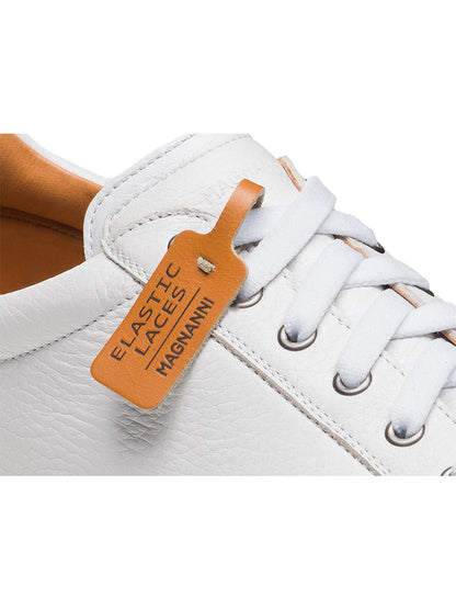 Close-up of the Magnanni Cote Lo Stretch-Lace in Tumbled White/White, featuring white elastic laces and a tan leather tag labeled "ELASTIC LACES MAGNANNI," highlighting its convenient stretch-lace system.