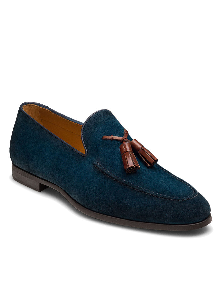 The Magnanni Dion in Navy Suede is a dark blue Línea Flex tassel loafer made from suede calfskin leather with brown tassels, low heel, and visible stitching, shown against a white background.