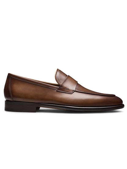 The Magnanni Duerro in Brown, a sleek minimalist penny loafer with a low heel, is displayed in side profile against a white background.