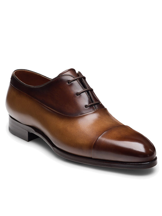 The Magnanni Duke in Tabaco/Brown is a polished brown leather dress shoe with a cap toe design and dark laces, exemplifying exquisite craftsmanship and sophistication.