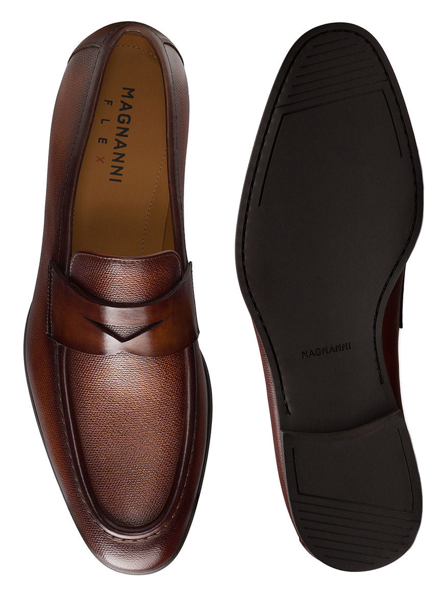 Top and bottom view of a pair of Magnanni Dumas loafers in Cognac, showcasing the sophisticated textured leather upper design and flexible black rubber soles.