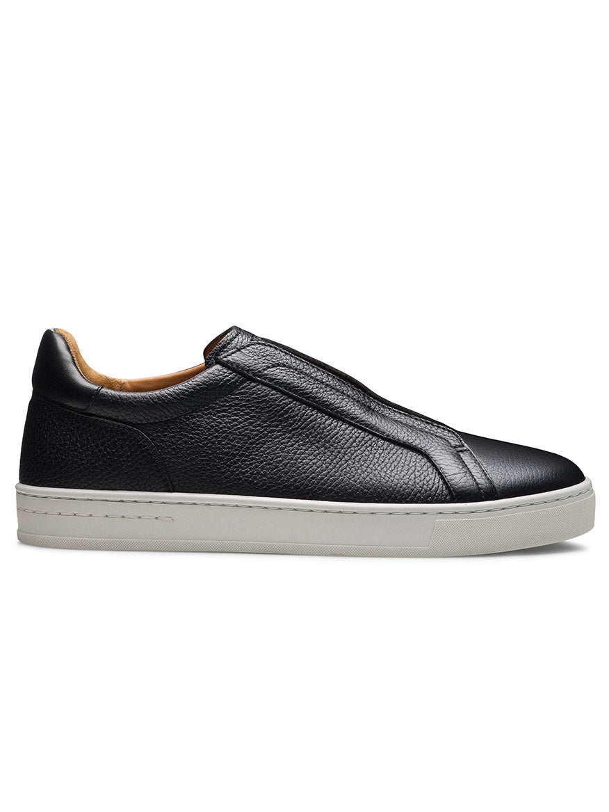The Magnanni Gasol in Tumbled Black is a black leather slip-on sneaker with a textured surface, hidden elastic gore, and a white rubber sole, displayed from the side against a white background.