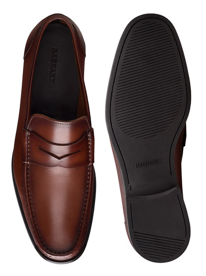 A pair of Magnanni Gentry Soft Penny loafers in Brandy, one shown from the top and the other showcasing the black rubber sole.