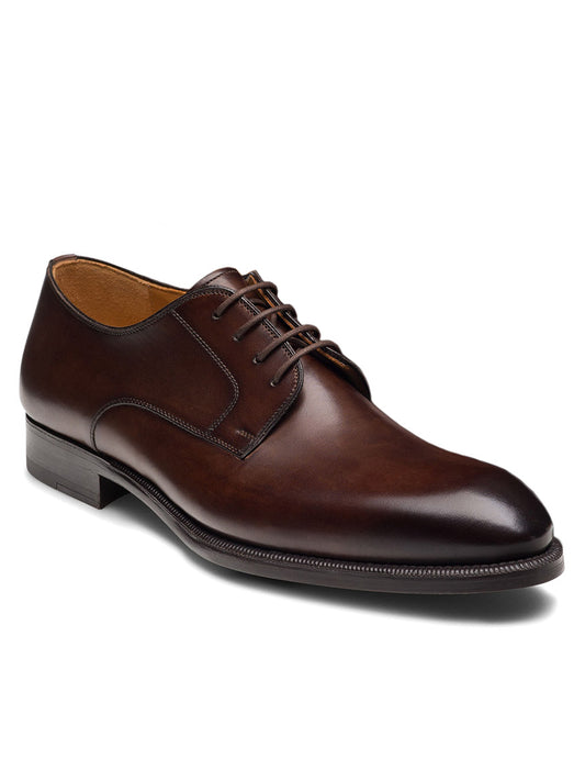 The Magnanni Haans in Brown is a men's leather dress shoe featuring a rounded toe, lace-up front, and stacked heel, shown on a white background—perfect for business attire.