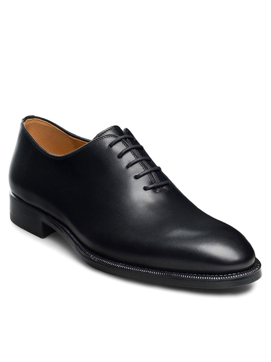 The Magnanni Hawkins in Black is a sleek single black leather Oxford shoe with a smooth finish, featuring closed lacing, a low heel, and a round toe.