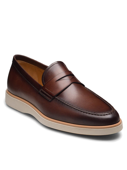 The Magnanni Lalo II in Brown is a men's leather loafer with a white rubber sole, classic penny strap, and detailed stitching around the toe.