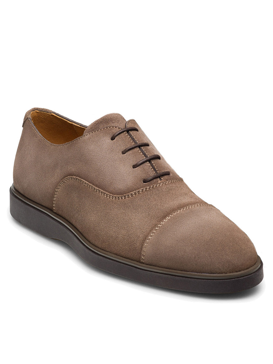 The Magnanni Landis in Schore Suede is a brown suede oxford dress shoe featuring black laces, a cushioned rubber sole, and a stylish cap toe.