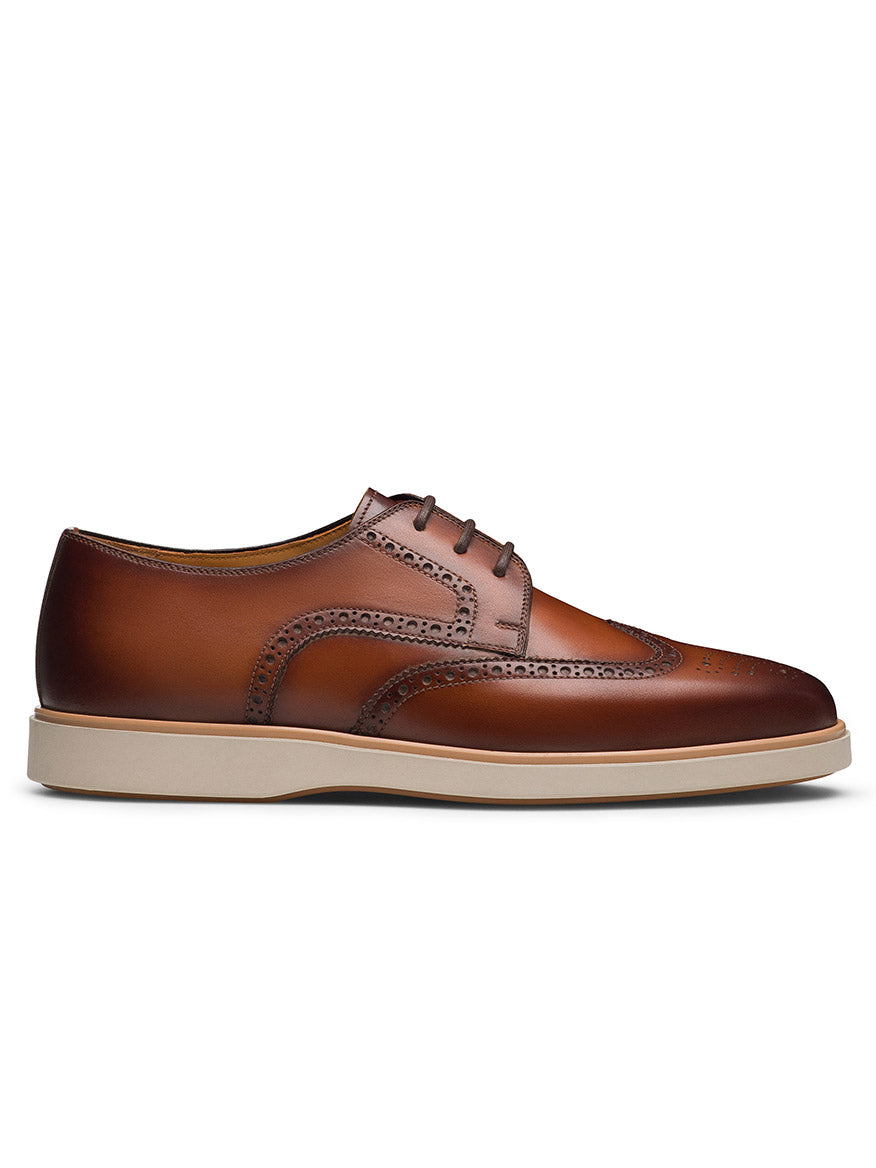 Magnanni Leonel II in Cognac: a premium leather hybrid wingtip derby men's dress shoe with brogue detailing, decorative perforations, and a white rubber sole, shown from the side on a plain background.