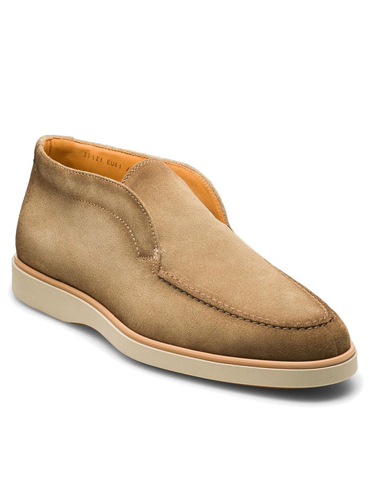 The Magnanni Loda in Taupe Suede is a single slip-on desert boot, featuring beige suede with a light-colored sole, a soft round toe, minimal stitching detail, and a cushioned footbed for maximum comfort.