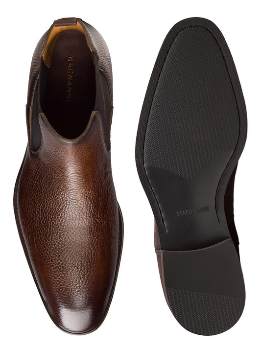 The Magnanni Lonny in Tumbled Tabaco features brown full-grain leather slip-on dress shoes with textured uppers and black rubber soles, shown from the top and bottom—ideal for those seeking refined, luxury footwear.