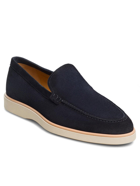 A single navy suede loafer from the Magnanni Lourenco line, highlighted by crisp white soles and an elegant design free of visible laces. This apron toe loafer features a lightweight rubber sole and a cushioned footbed for supreme comfort. The shoe is showcased on a plain white background.