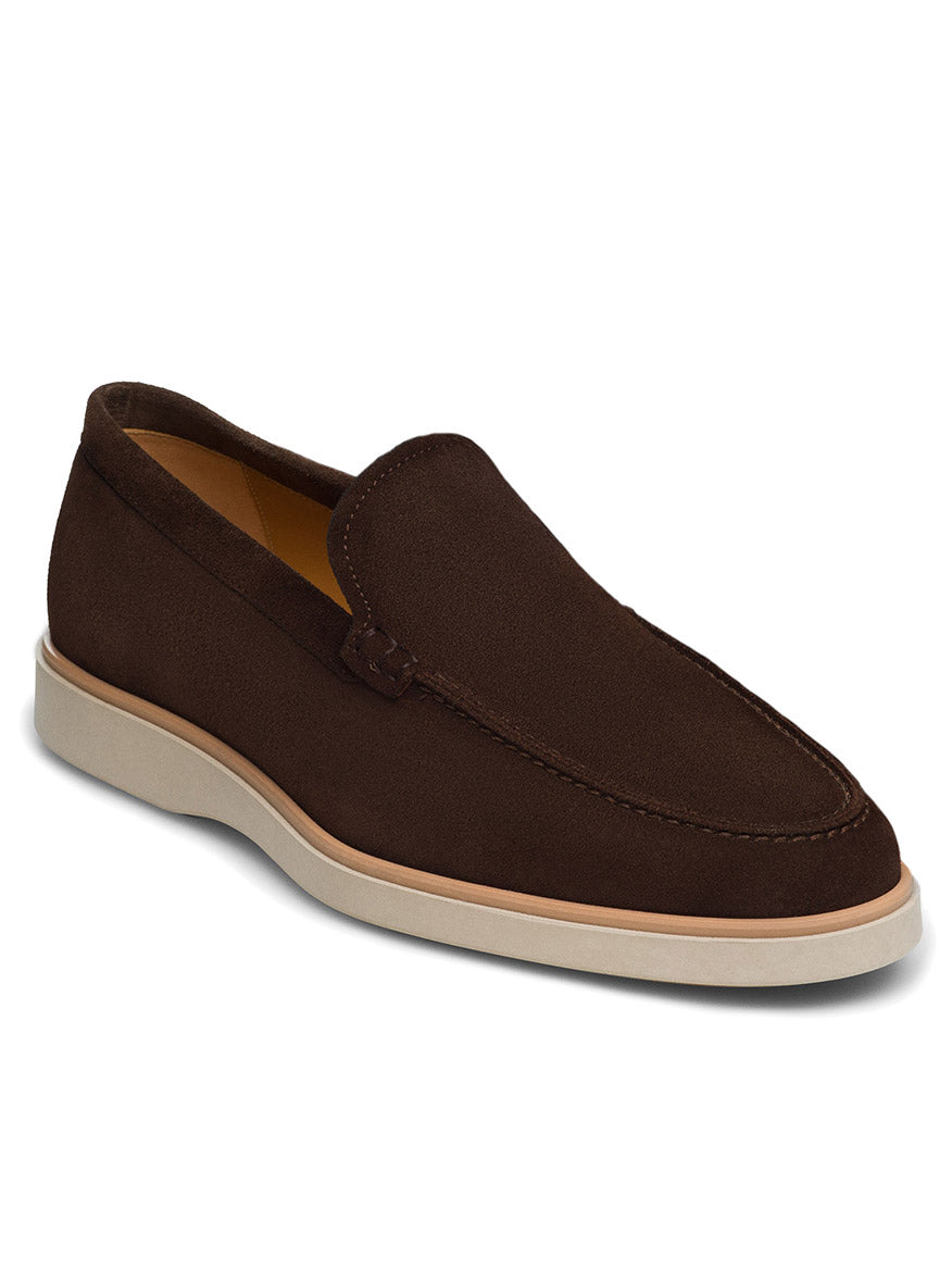 The Magnanni Lourenco in Midbrown Suede is a slip-on apron toe loafer crafted from brown suede, featuring a white rubber sole, low heel, and rounded toe design to ensure all-day comfort.