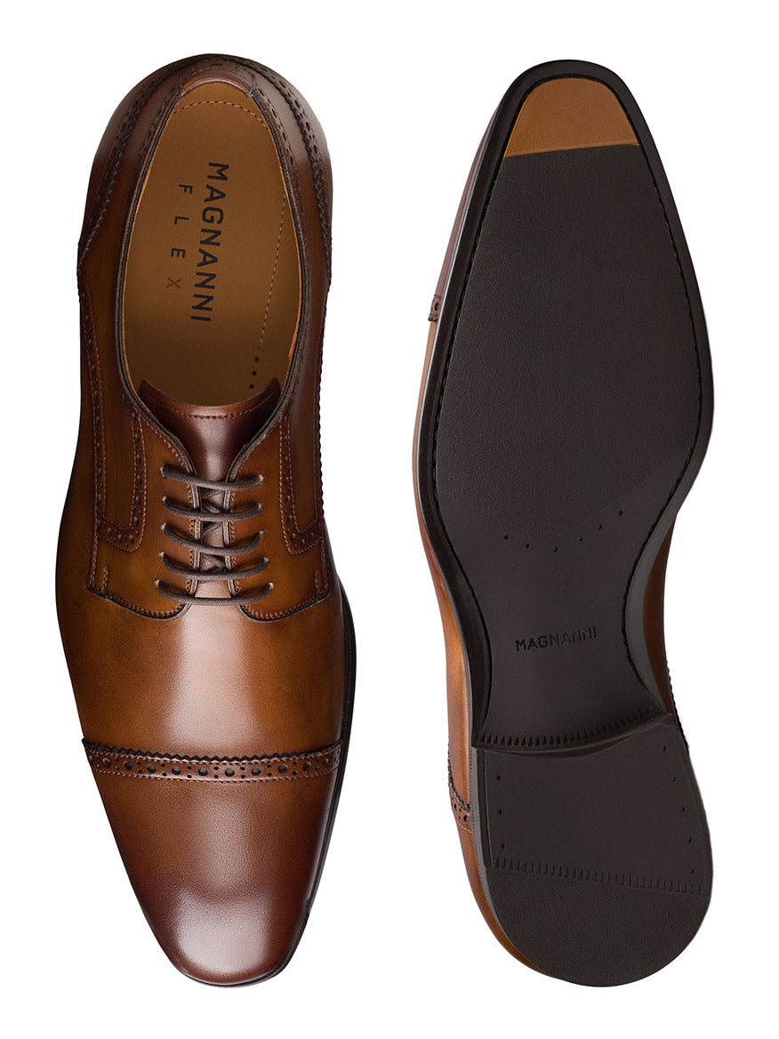 The Magnanni Macsen in Tabaco are brown leather dress shoes with laces, a dark rubber sole, and handcrafted Bologna construction for superior comfort, shown from top and bottom views.