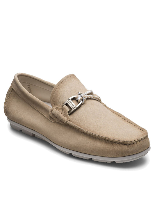 The Magnanni Monterey Braid Bit in Tierra Suede is a beige suede loafer with moccasin-style stitching, white braided leather lace, silver buckle accent, and a rubber sole.