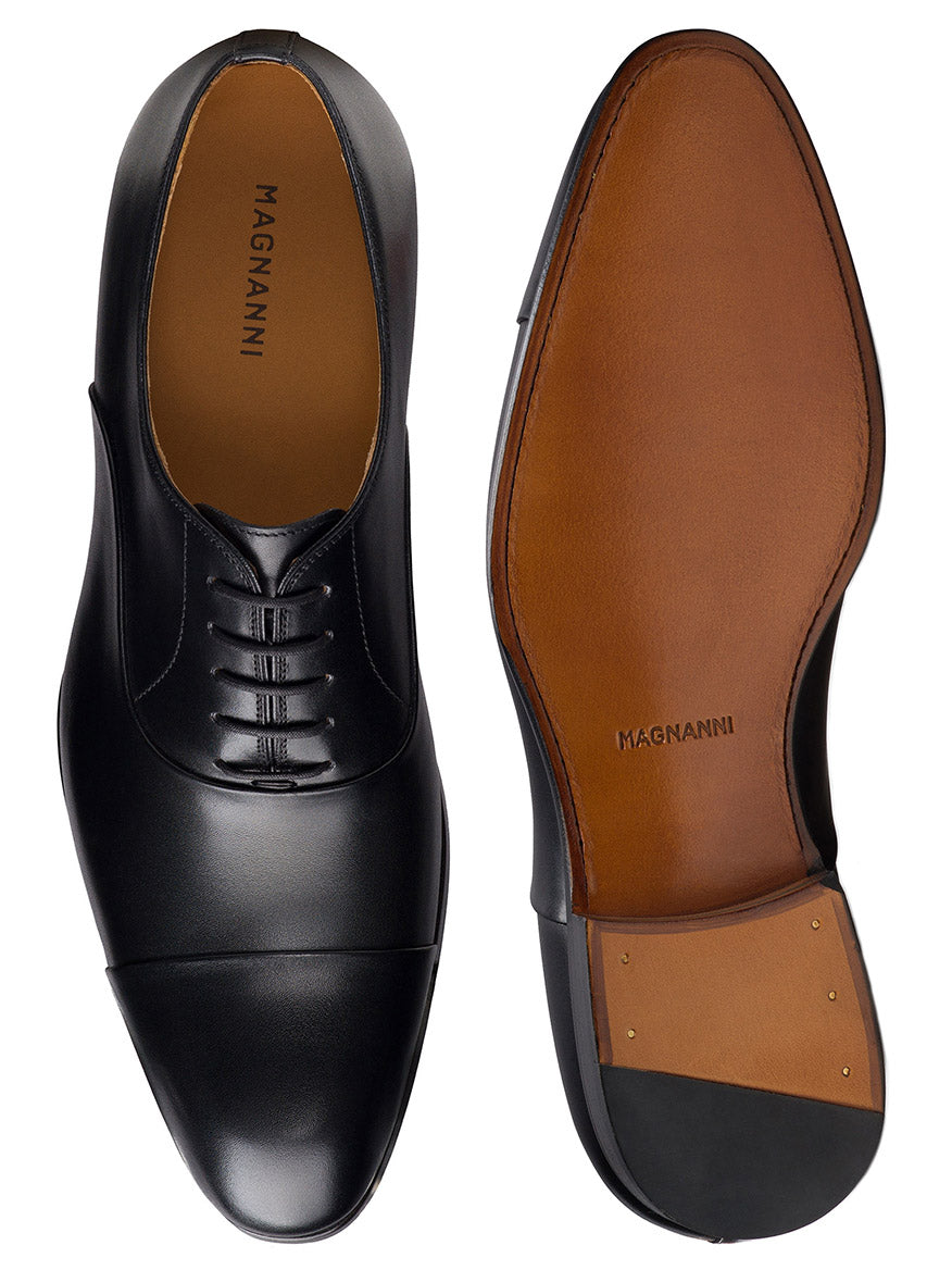 Magnanni Naxos in Black men’s formal Oxford dress shoes, shown from top and bottom, feature a classic cap toe and leather soles with nail-detailed heels—perfect as tuxedo shoes for any formal event.