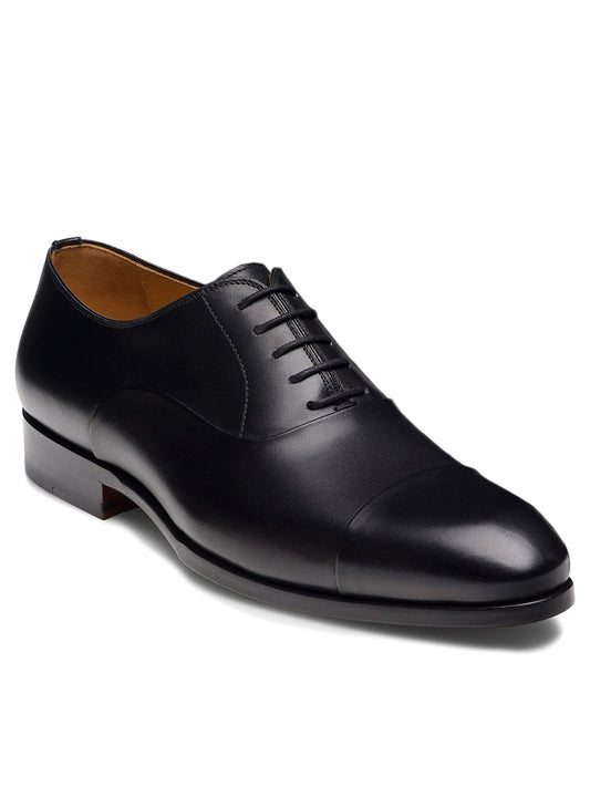 Magnanni Naxos in Black is a black leather Oxford dress shoe with a closed lacing system and cap toe, ideal as men's formal shoes, shown against a white background.