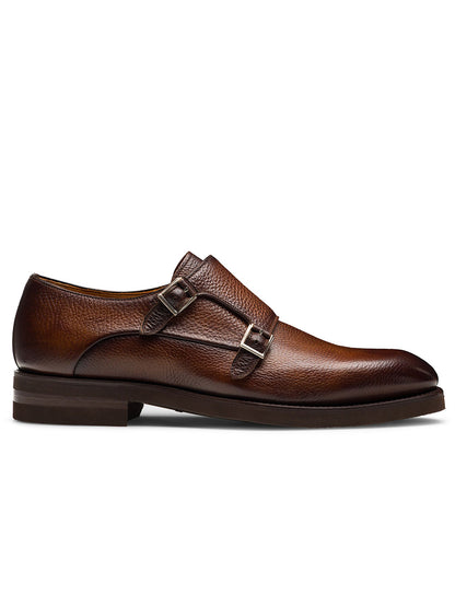 The Magnanni Omnia in Tumbled Tabaco is a brown leather dress shoe with a double monk strap, low heel, and textured finish, displayed in a left side profile view on a white background.