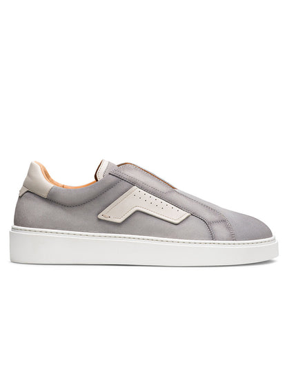 The Magnanni Phoenix Slip in Metal Suede & White is a gray slip-on sneaker with leather accents, a white sole, beige details, and a minimalist design, displayed in side profile against a white background.