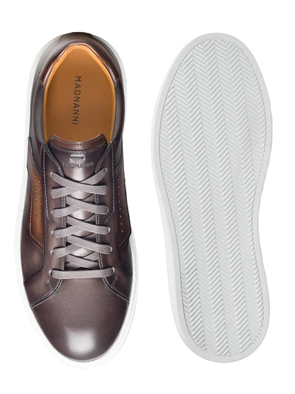 Top view of a Grey/Brown Magnanni Phoenix sneaker next to its sole, featuring wing-inspired leather accents for a sophisticated sporty appeal.