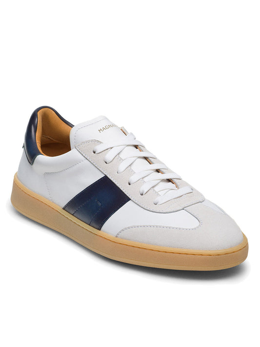 The Magnanni Primera in White/Navy sneaker showcases a gum sole, complementing its white upper with a navy stripe and premium suedes, finished with crisp white laces.