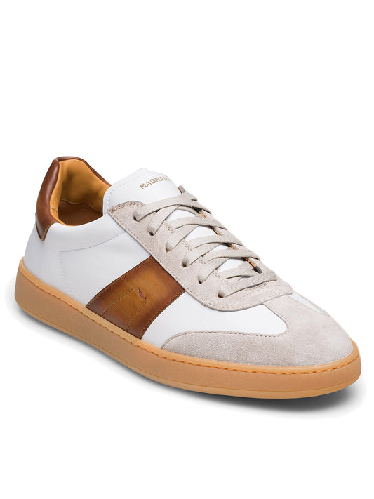 Discover the Magnanni Primera in White/Cuero: a stunning sneaker featuring a gum sole, premium suedes, sleek white laces, and a rich brown leather stripe on the side. It effortlessly combines style and comfort.