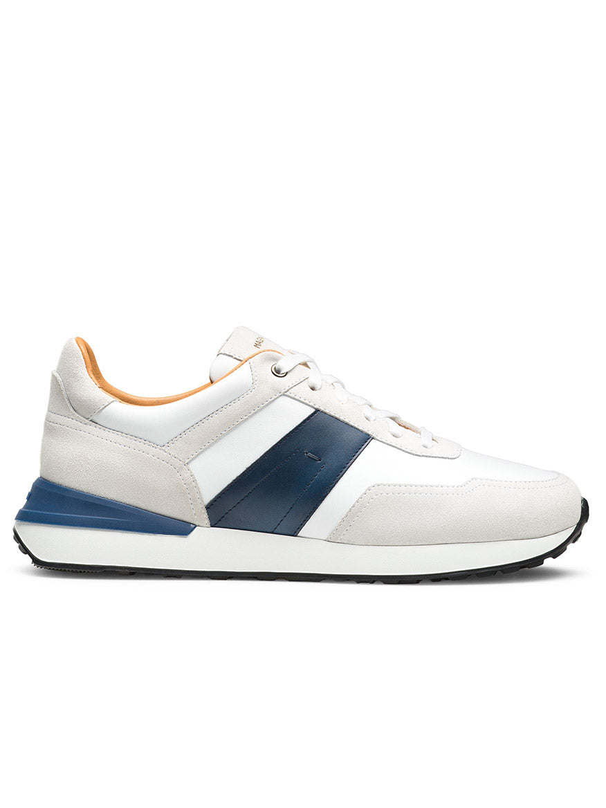 The Magnanni Sentro in White/Navy is a minimalist sneaker featuring white and beige full-grain leather, a navy stripe, white laces, and a black sole, shown from the side.