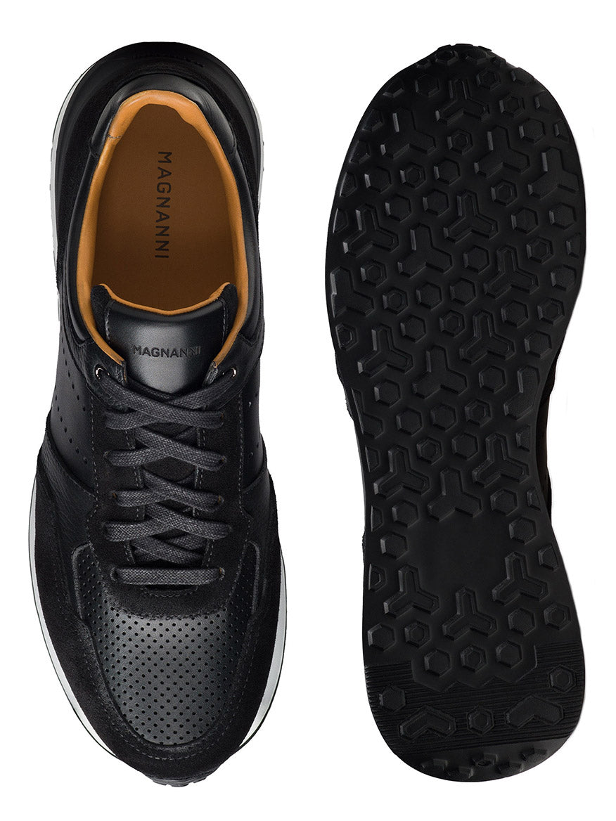 Magnanni Sona III sneakers in black featuring a perforated design on top, orange lining, and black laces. The bottom view showcases a textured sport sole pattern.