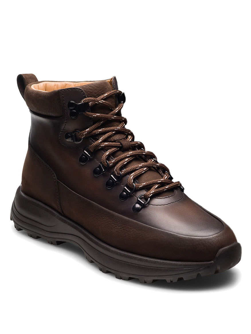 A single Magnanni Strata boot in tumbled brown nubuck, handmade in Portugal, featuring black metal eyelets and brown laces, displayed at a three-quarter angle on a white background.