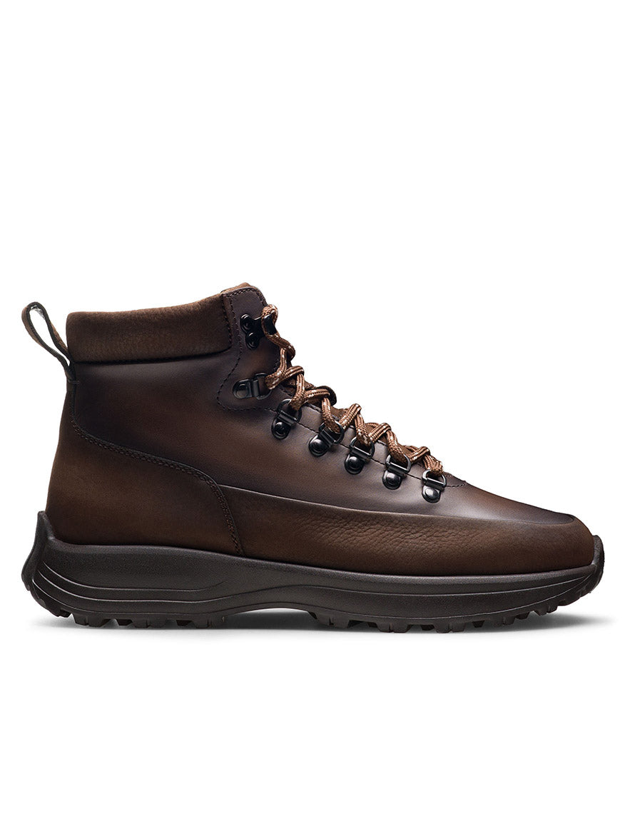 Side view of the Magnanni Strata in Tumbled Brown Nubuck, a luxury hiking boot featuring dark brown nubuck leather, a black sole, metal eyelets, and brown laces; handmade in Portugal and isolated on a white background.