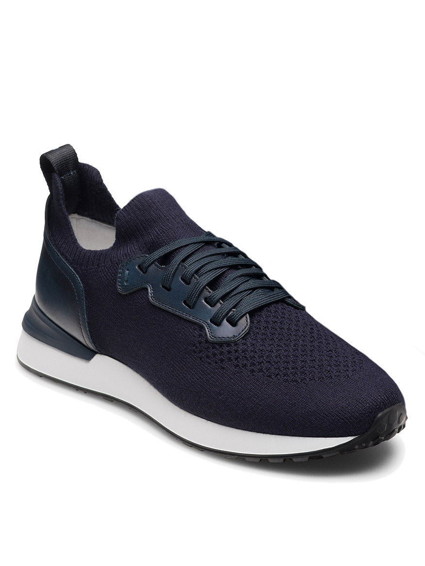 The Magnanni Stratus LyteKnit in Navy is a knit sneaker featuring dark laces, a cushioned footbed, white midsole, and black outsole, shown from a front side angle.