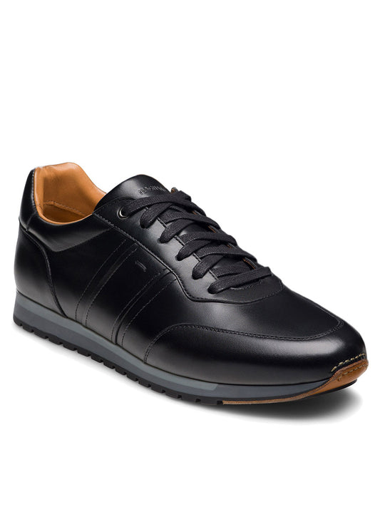 The Magnanni Ventura in Black is a men’s leather sneaker featuring black laces, subtle stitching, and a tan interior lining, displayed at a right angle on a plain white background.