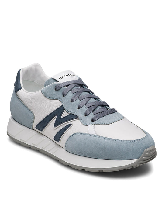 The Magnanni Yoki sneaker in Sky Blue Suede & Tumbled White features gray laces, a dark blue "M" on the side, an athletic-style sole, and is shown on a plain white background.