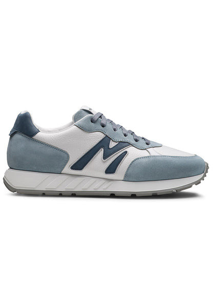 The Magnanni Yoki in Sky Blue Suede & Tumbled White is a retro-inspired sneaker featuring blue and white colors, a bold "N" logo, white midsole, grey outsole, blue laces, and a comfortable athletic-style sole.
