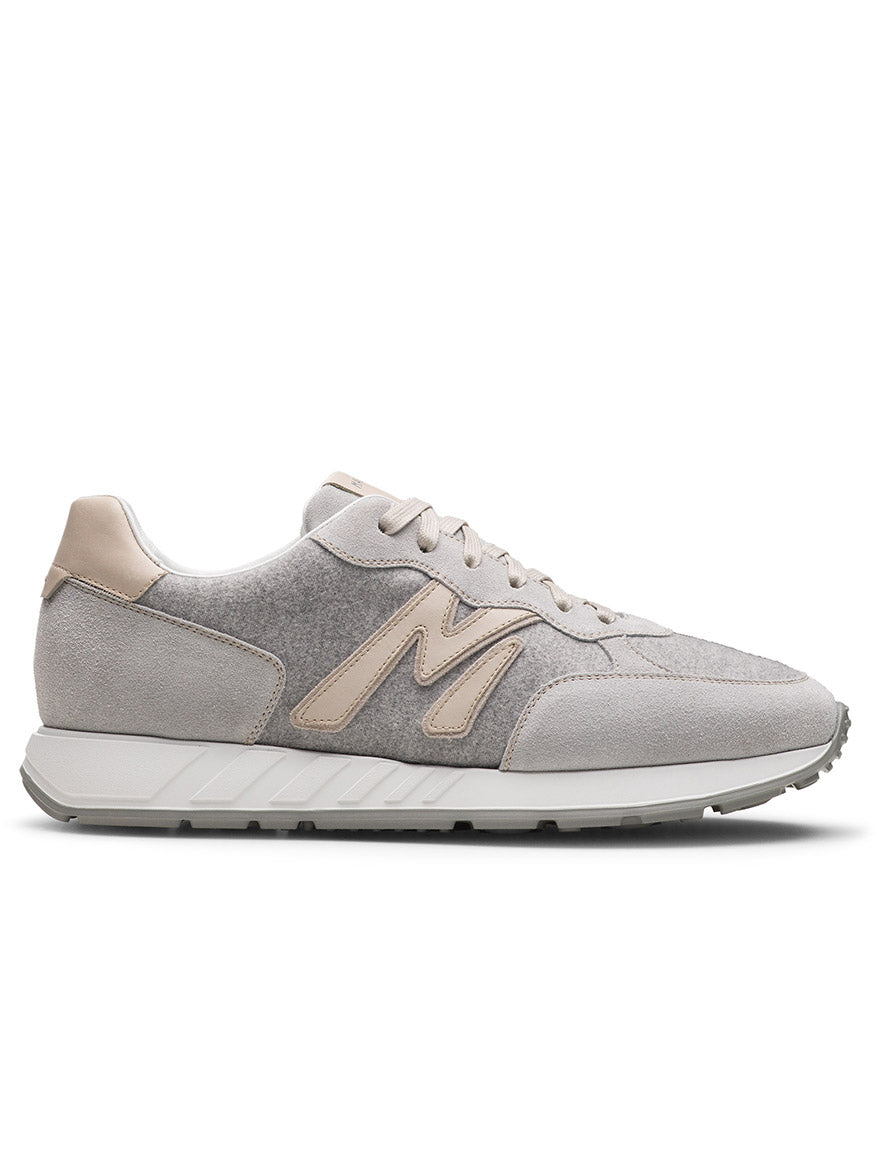 The Magnanni Yoki in Metal Suede & Bone is a light grey, retro-inspired sneaker with beige suede accents, white laces, a beige "M" logo, and an athletic-style sole shown from the left side profile.