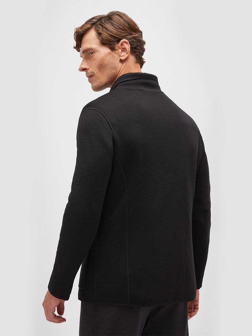 Man in a Maurizio Baldassari Accademia Wool Swacket in Black viewed from the side, looking over his shoulder against a plain white background.