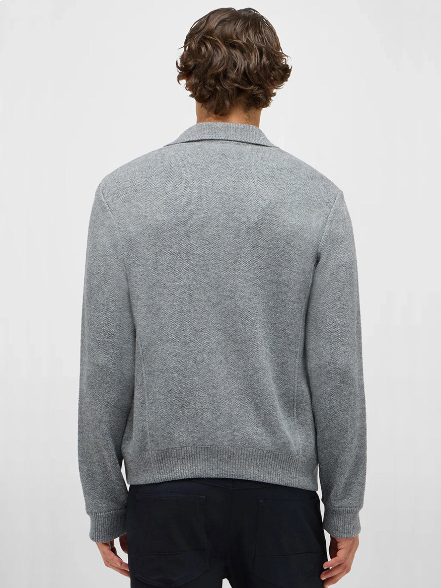 A person with short, wavy brown hair is shown from the back, wearing the Maurizio Baldassari Pique Knit Cashmere Blend Blouson in Light Grey and dark pants against a plain light background.