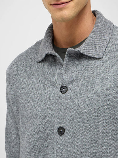 A person wearing a Maurizio Baldassari Pique Knit Cashmere Blend Blouson in Light Grey over a dark t-shirt, shown from shoulders to upper chest.