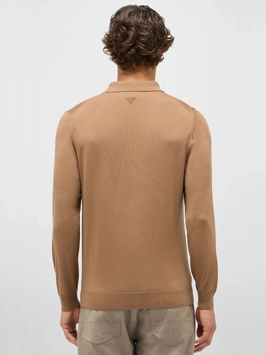 A person with short, wavy brown hair is seen from behind wearing the Maurizio Baldassari 3-Button Long Sleeve Extrafine Wool Polo in Camel and light beige pants against a plain light background.