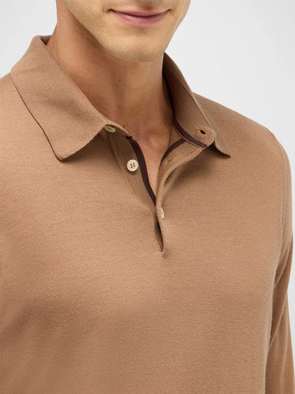 A person wears the Maurizio Baldassari 3-Button Long Sleeve Extrafine Wool Polo in Camel, made in Italy, shown from shoulders to mouth.