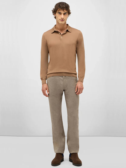 A man faces forward, wearing the Maurizio Baldassari 3-Button Long Sleeve Extrafine Wool Polo in Camel, light brown pants, and brown shoes against a plain light gray background.