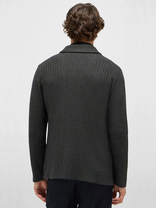 A person with curly hair is shown from the back, wearing a dark green Maurizio Baldassari Ribbed Knit Marled Shacket against a plain light background.