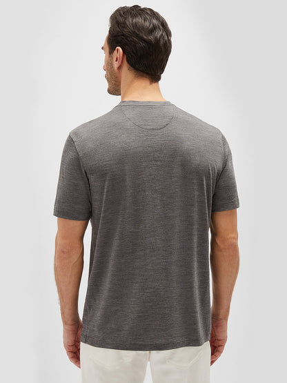 A man with short dark hair is wearing a gray short-sleeved Maurizio Baldassari Linate Techmerino Short Sleeve T-Shirt in Medium Heather Grey, viewed from the back against a plain light gray background.