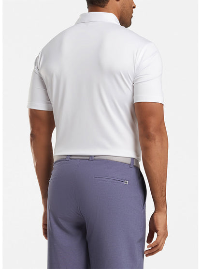 Man wearing a Peter Millar Solid Performance Jersey Polo in White [Sean Self Collar] and purple trousers, viewed from the back.
