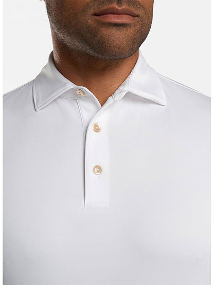 Close-up of a man wearing a Peter Millar Solid Performance Jersey Polo in White with the Sean Self Collar partially visible, designed with UPF 50+ sun protection.