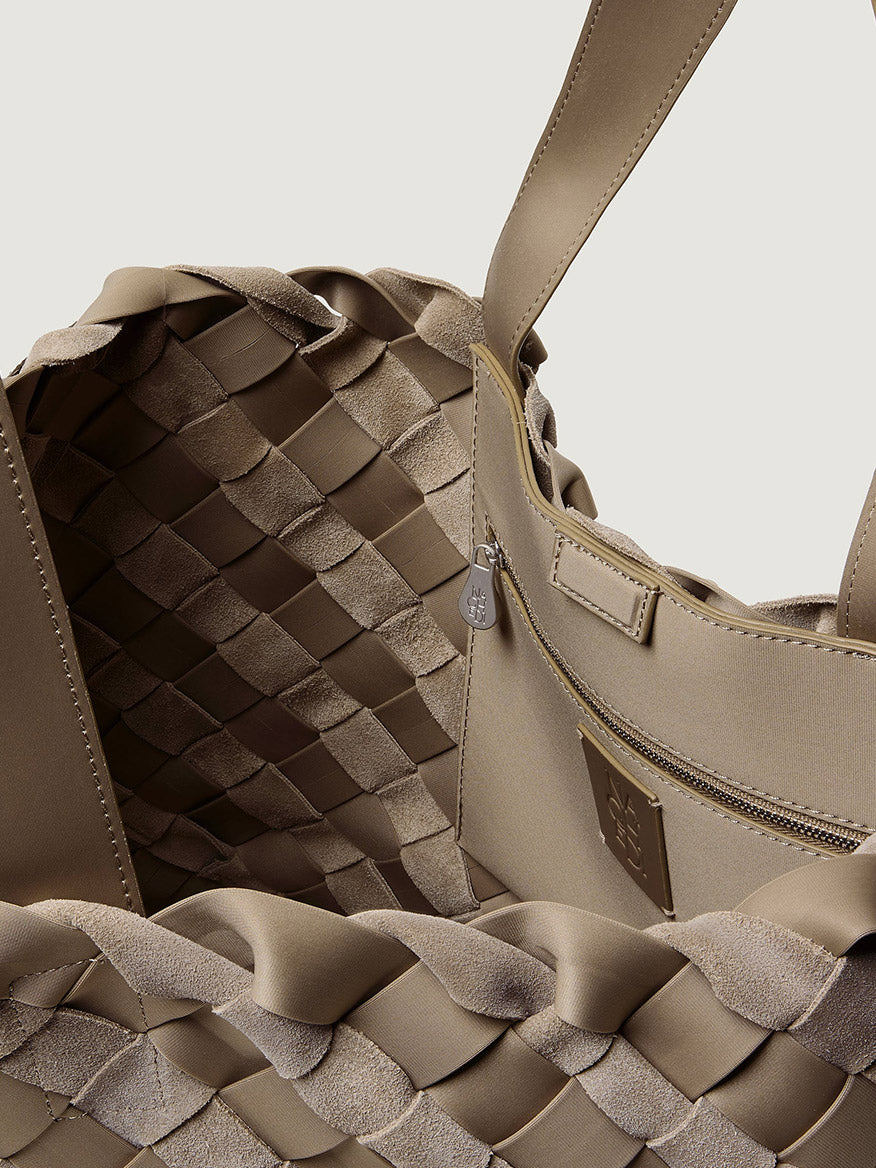 Interior of a beige handwoven Naghedi Como Medium Tote Suede & Neoprene in Bluff, featuring a zippered pocket and matching pouch.