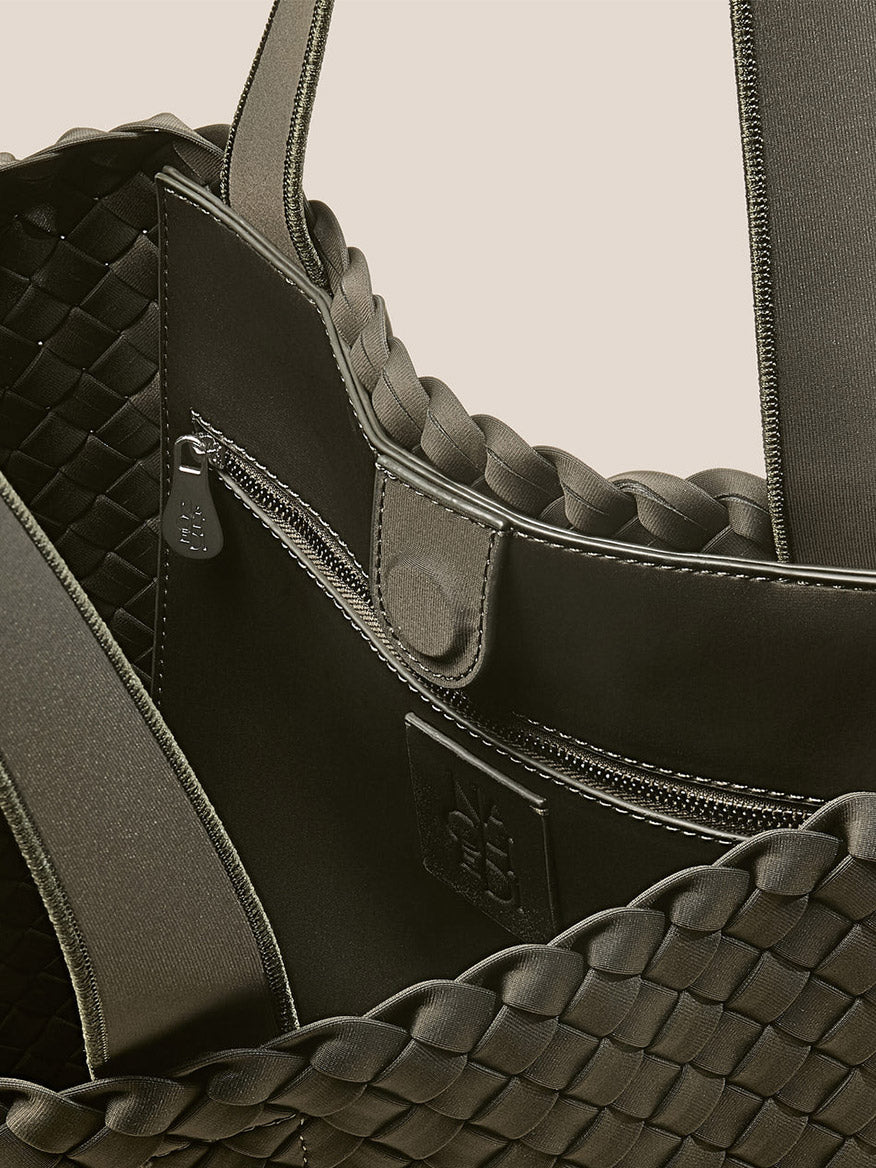 Close-up of the Naghedi Como Shopper Tote in Olive, highlighting its zippered pocket, snap closure, and detailed stitching on dark olive material for a stylish unisex design.