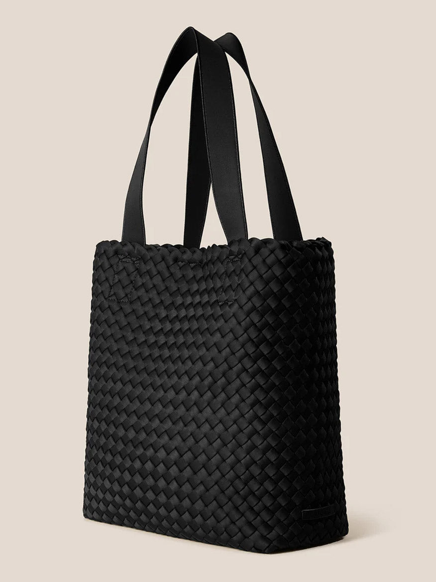 The Naghedi Como Shopper Tote in Onyx, a handwoven unisex black bag with two flat handles, is shown against a plain beige background.