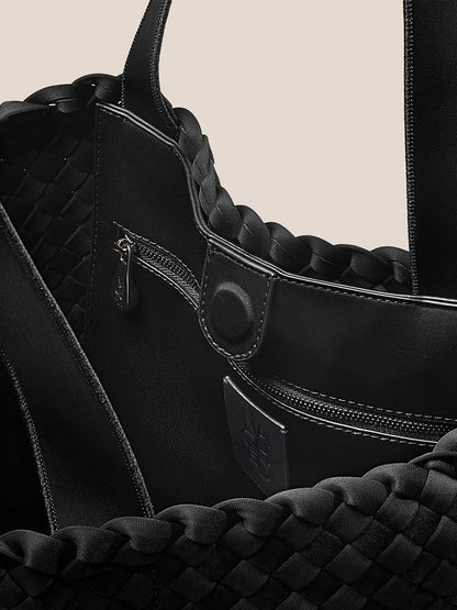 Close-up of the interior of the Naghedi Como Shopper Tote in Onyx, featuring a zippered pocket, snap button closure, and detailed stitching.