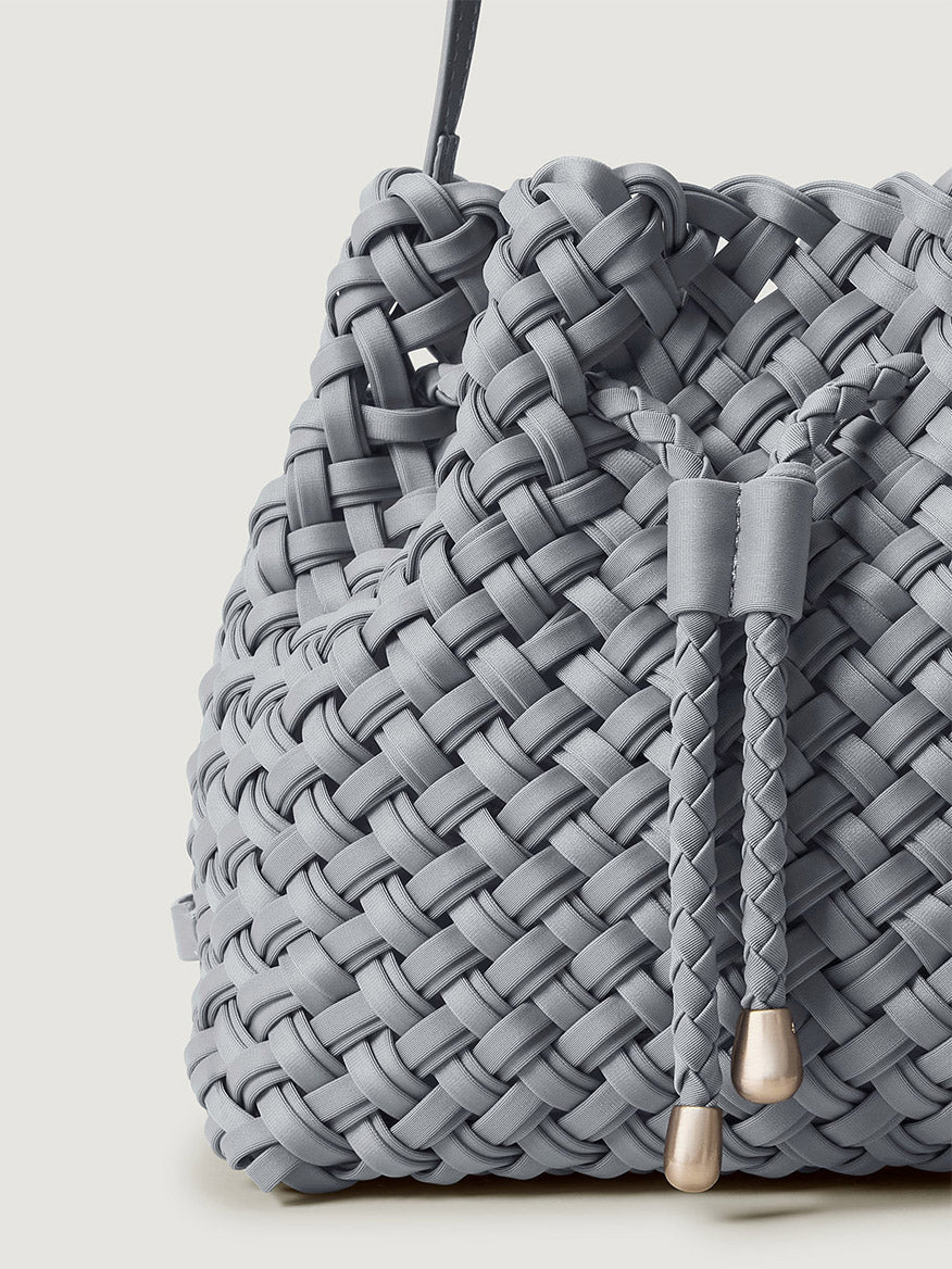Naghedi Gramercy Bucket Double Weave in Marina, a light blue handwoven bucket bag with a drawstring closure and metallic toggles.